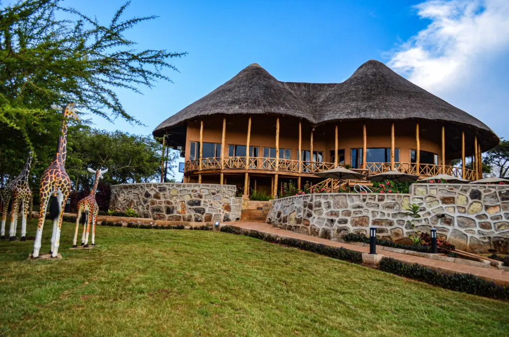 Thatched-roof lodge with giraffe sculptures