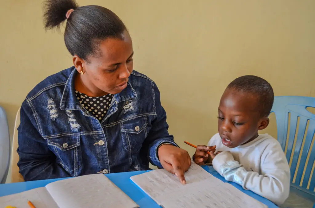 Adult teaching child in classroom