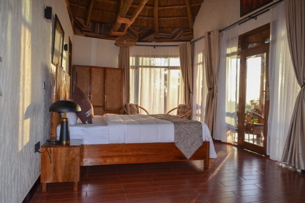 Sunlit King Room at Maasai EcoLodge Sunlit king room at Maasai EcoLodge featuring natural wood furnishings, local artwork, and views of the Tanzanian landscape