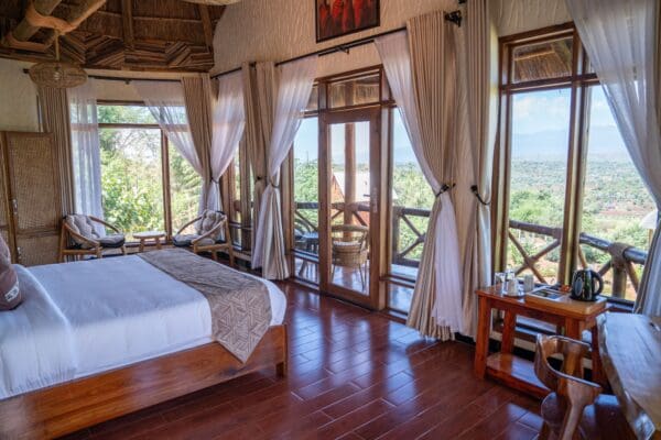 Sunlit King Room at Maasai EcoLodge Sunlit king room at Maasai EcoLodge featuring natural wood furnishings, local artwork, and views of the Tanzanian landscape